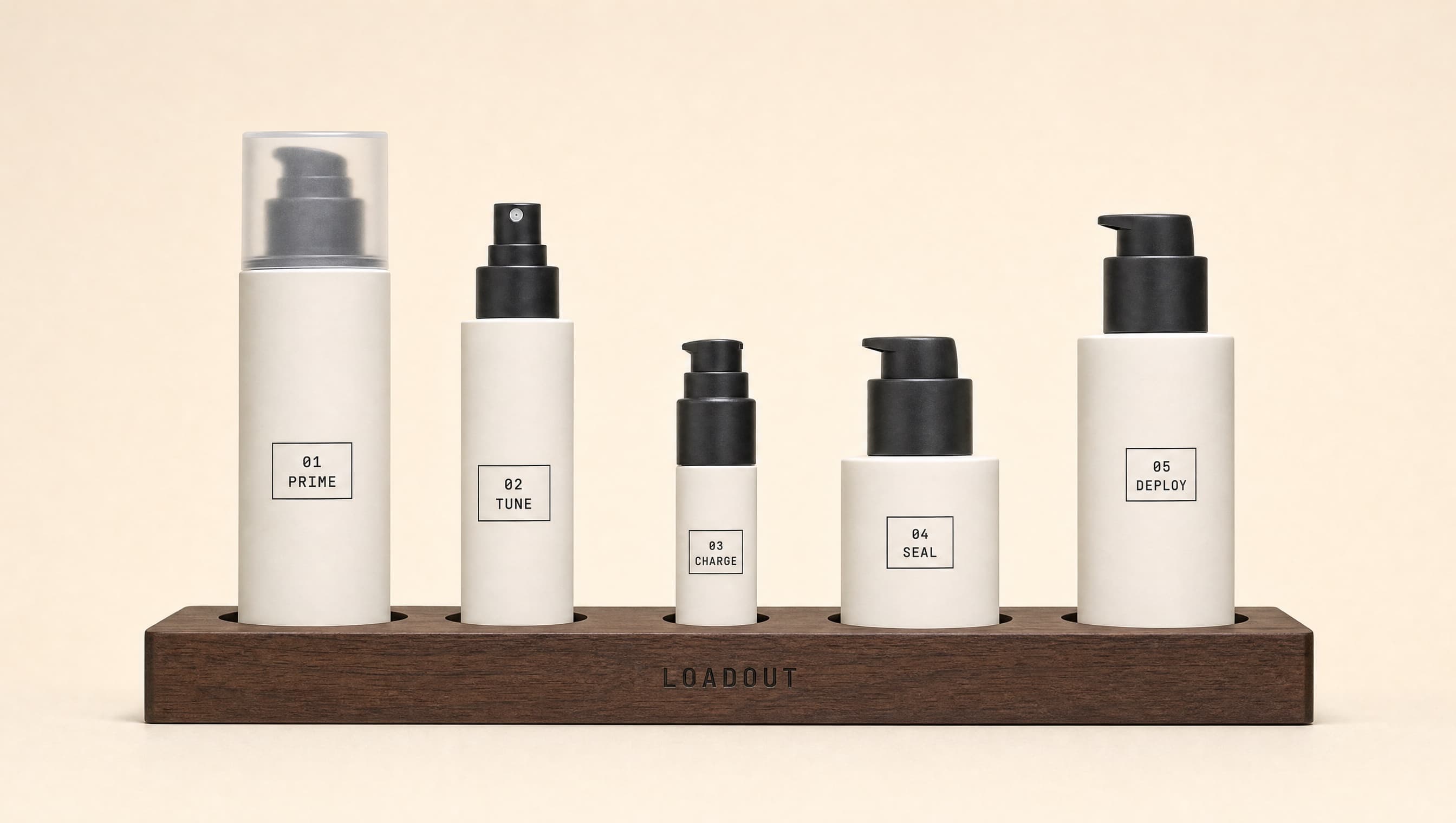 The five LOADOUT bottles seated in the walnut Loadout Station holder: 01 PRIME, 02 TUNE, 03 CHARGE, 04 SEAL, 05 DEPLOY